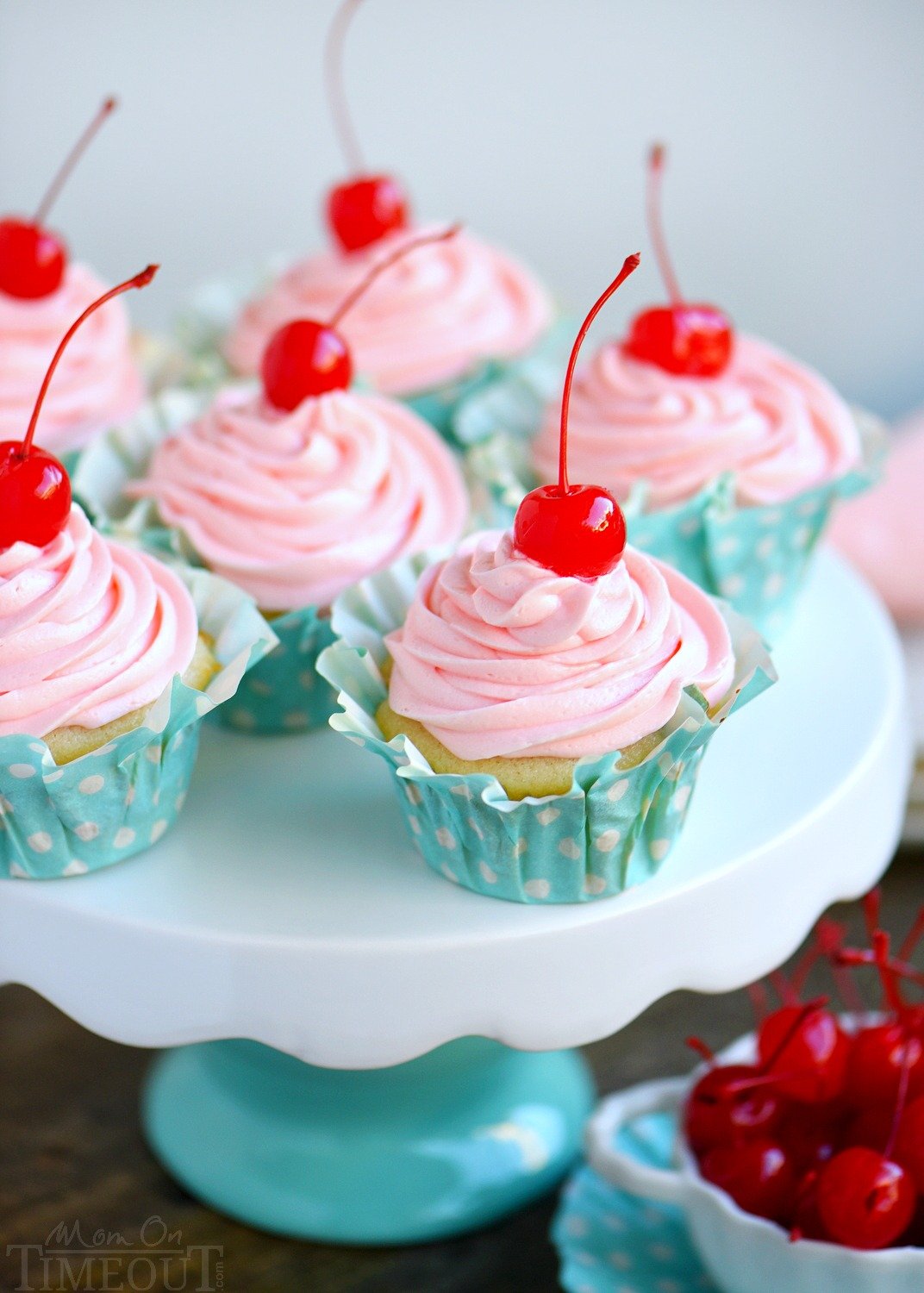 These Cherry Almond Cupcakes are so bright and festive - they're hard to resist! A beautiful almond cupcake, made from scratch, is topped with a cherry almond frosting that is just delightful! Topped with a cherry, these cupcakes are party-ready! // Mom On Timeout