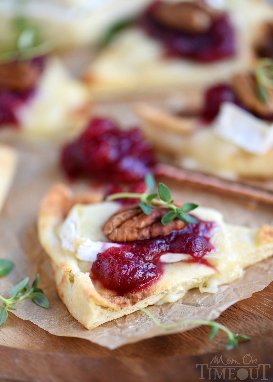 These Cranberry Pecan Brie Bites are perfect for holiday entertaining! Whether you make them for Thanksgiving, Christmas, or New Year's, no one will be able to resist the gooey melted brie, tart cranberry sauce, and toasted pecan atop a piece of naan! Easy and fabulous - just what holiday entertaining should be! // Mom On Timeout