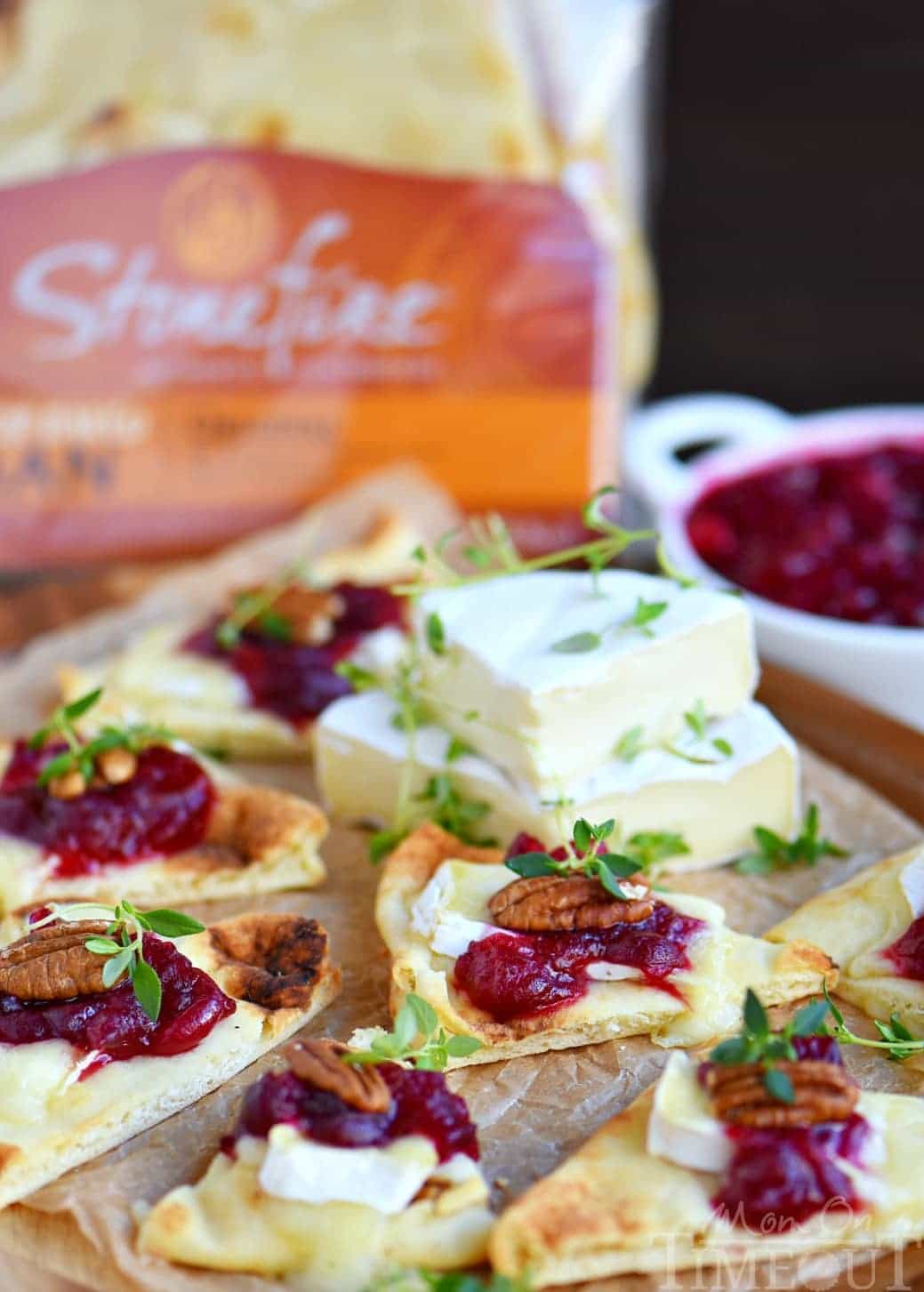 These Cranberry Pecan Brie Bites are perfect for holiday entertaining! Whether you make them for Thanksgiving, Christmas, or New Year's, no one will be able to resist the gooey melted brie, tart cranberry sauce, and toasted pecan atop a piece of naan! Easy and fabulous - just what holiday entertaining should be! // Mom On Timeout