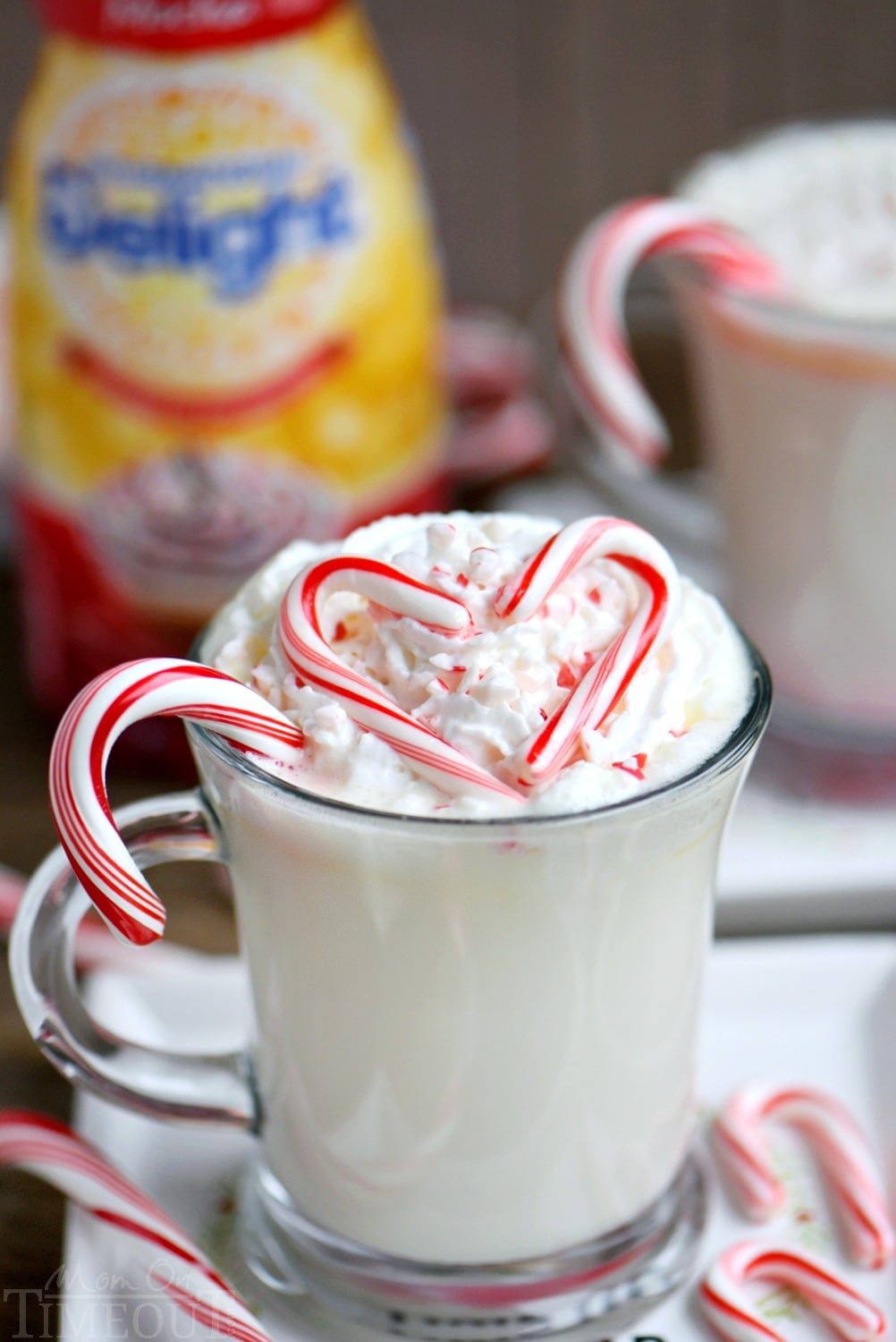 Creamy and decadent Slow Cooker Peppermint White Hot Chocolate! This easy recipe is the perfect way to warm up on a chilly day! Top with whipped cream and crushed candy canes for the ultimate peppermint experience! // Mom On Timeout