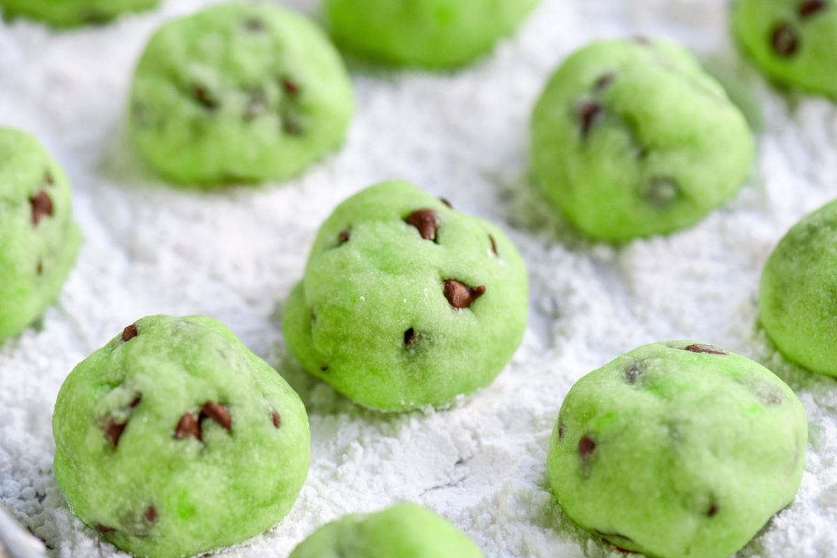 baked snowball cookies ready to be coated in powdered sugar.