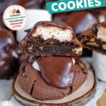Tall graphic showing chocolate marshmallow cookies stacked with the top cookie cut in half showing the marshmallow center. Text overlay at the top and bottom of the image.