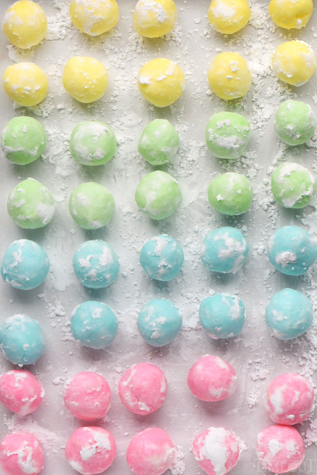 Easy cream cheese mints recipe shown in four colors rolled into balls ready to be pressed into mints.