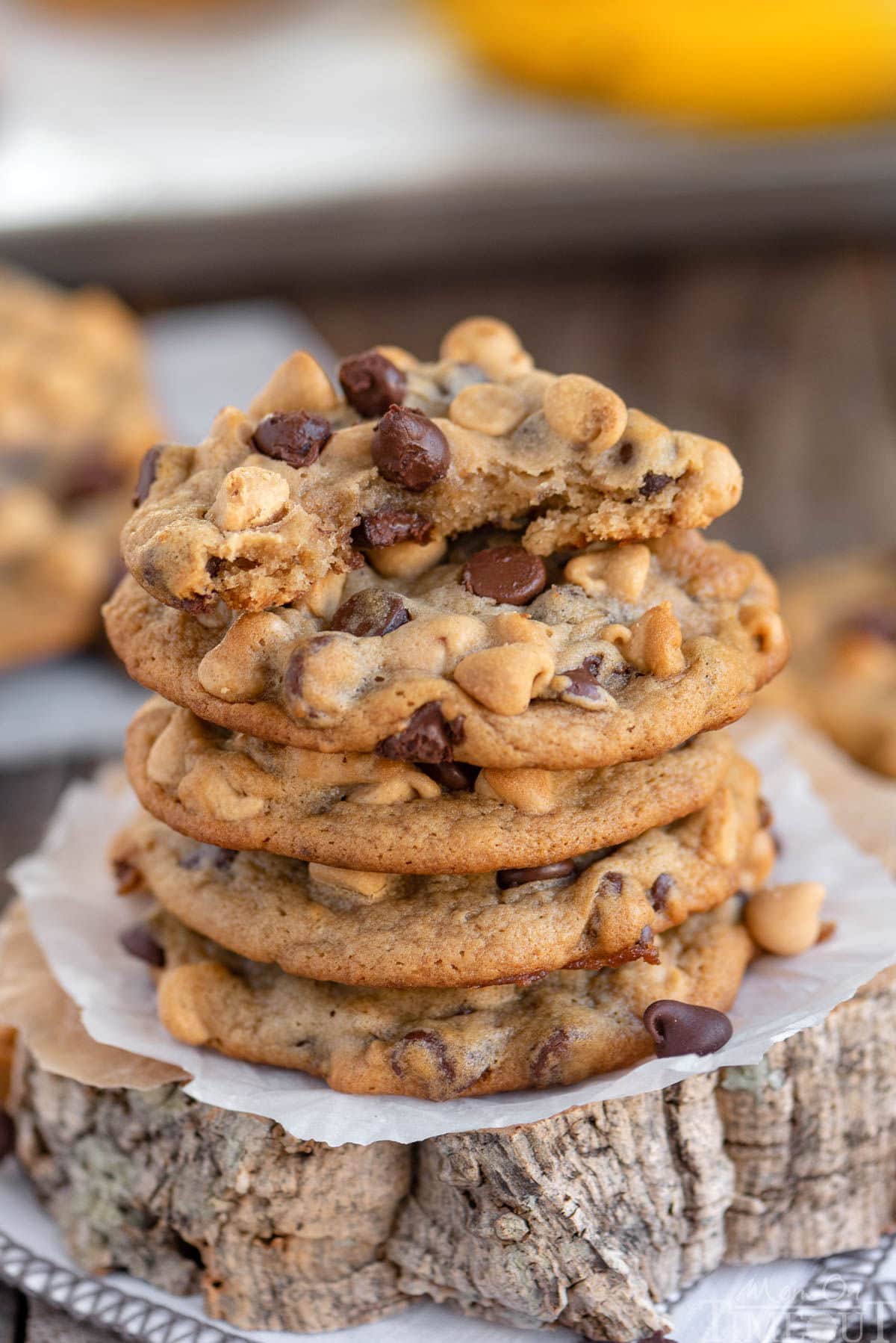 Stack of peanut butter banana chocolate chip cookies and top cookie has been torn in half.