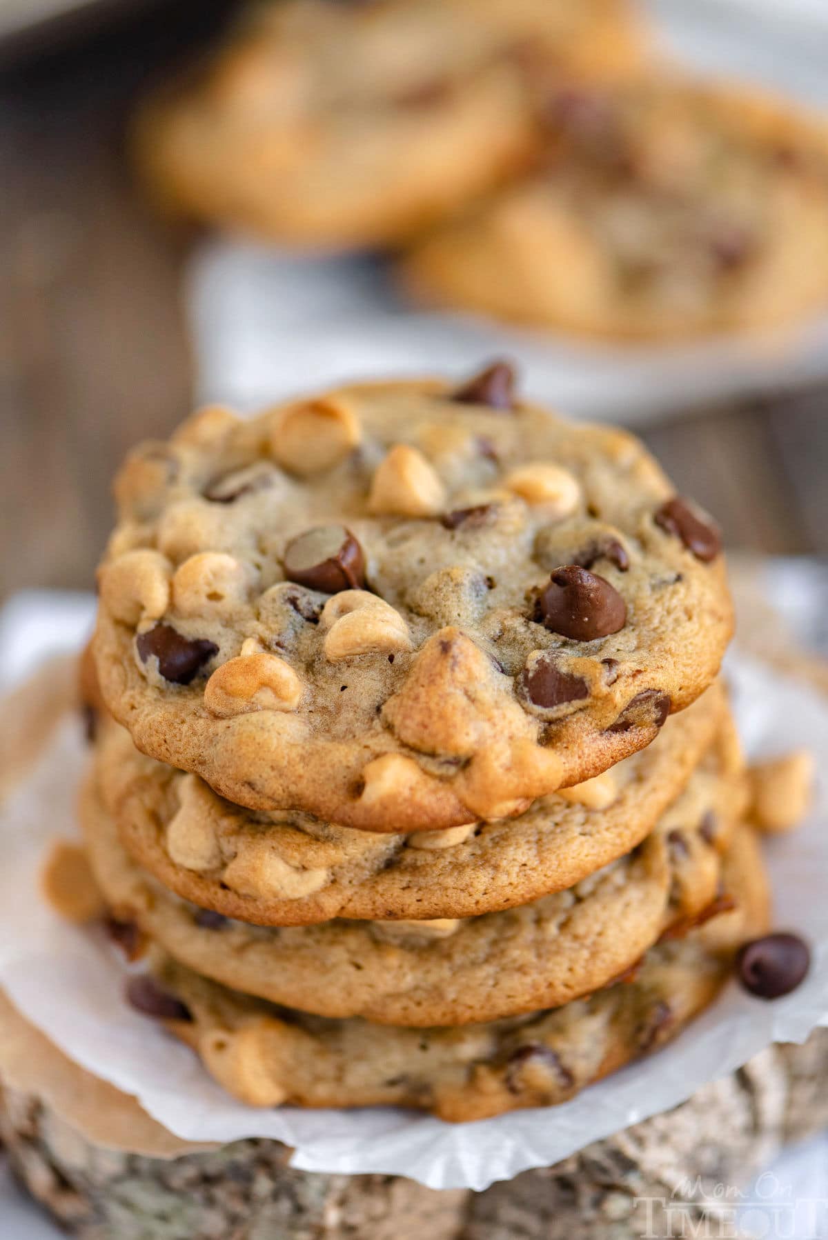 Stack of four peanut butter banana chocolate chip cookies on parchment paper.