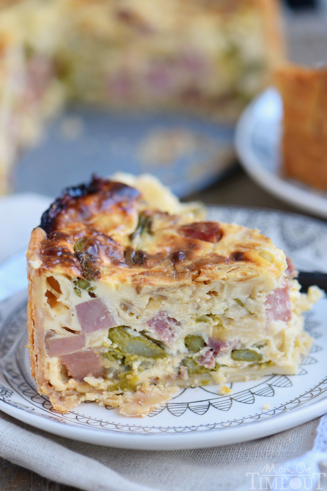 This Deep Dish Ham and Asparagus Quiche with caramelized onions is the perfect addition to your holiday brunch menu! Make it the day before and serve cold or room temperature - both ways are delicious! Also makes a hearty dinner! // Mom On Timeout