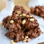 peanut clusters made with toffee piled high on a crumpled piece of parchment.