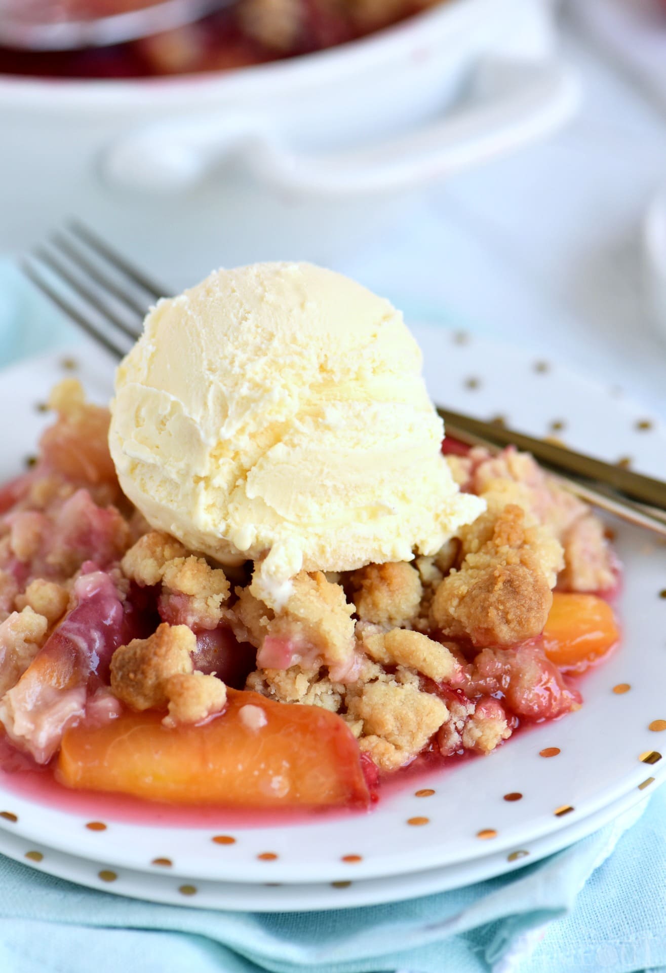 This easy Raspberry Peach Crumble is the perfect summer treat! Fantastically easy and amazingly delicious - this is one dessert no one will be able to resist! // Mom On Timeout #peachcrumble #peachcobbler #peach #raspberry #summer #desserts #baking #easy raspberry peach crumble with vanilla ice cream on plate