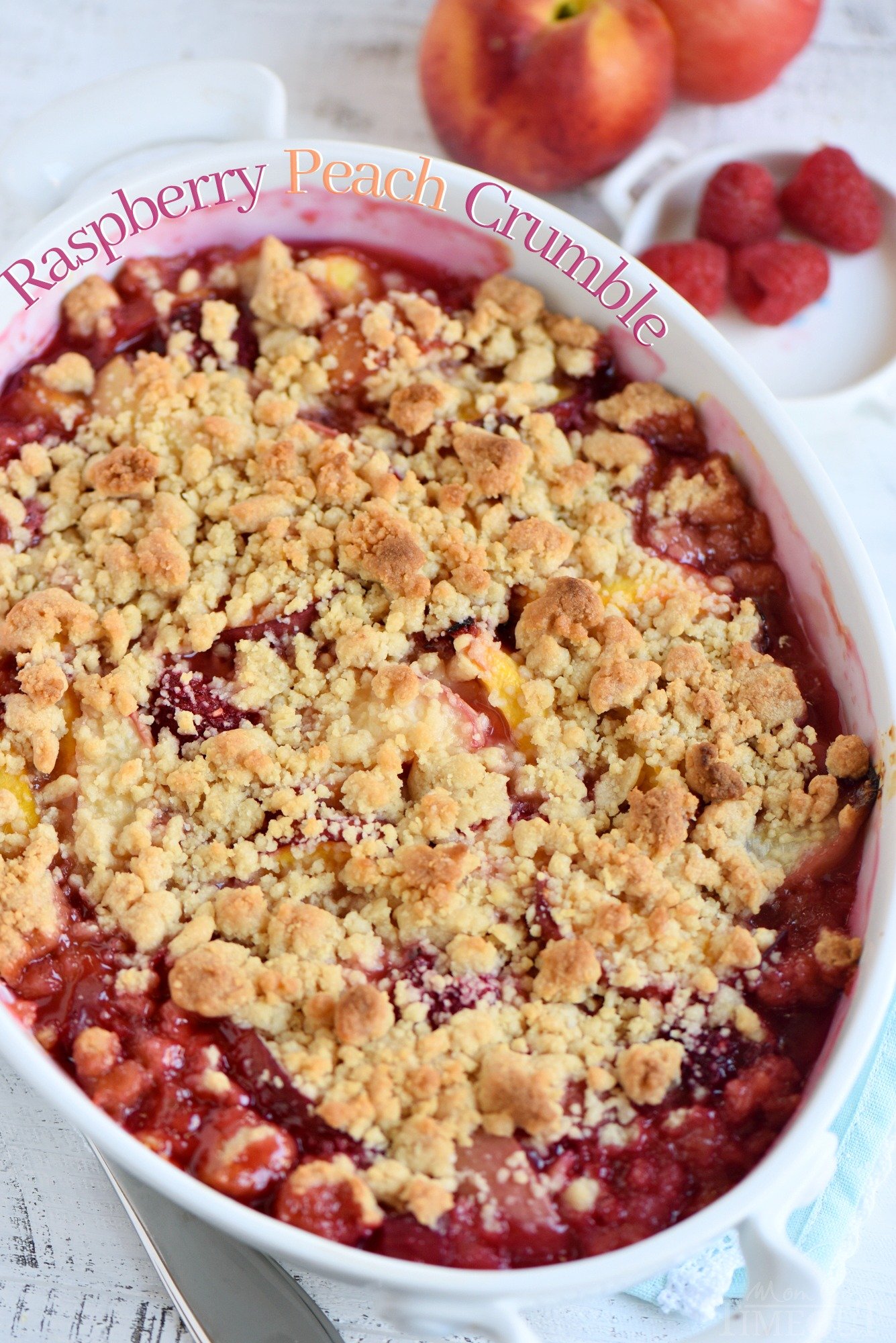 This easy Raspberry Peach Crumble is the perfect summer treat! Fantastically easy and amazingly delicious - this is one dessert no one will be able to resist! // Mom On Timeout #peachcrumble #peachcobbler #peach #raspberry #summer #desserts #baking #easy peach crumble with raspberries nectarines and easy topping in dish with peaches and raspberries