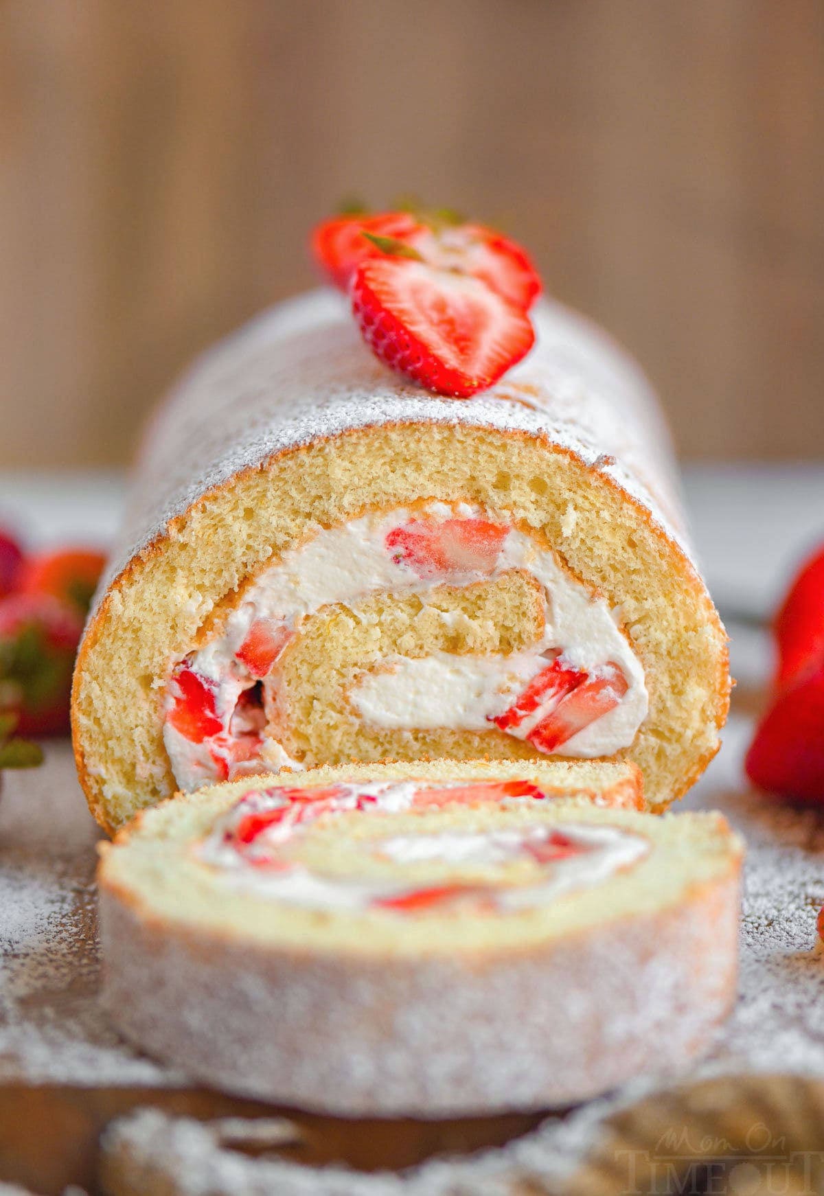 Front view of strawberry cake roll with one slice cut off.