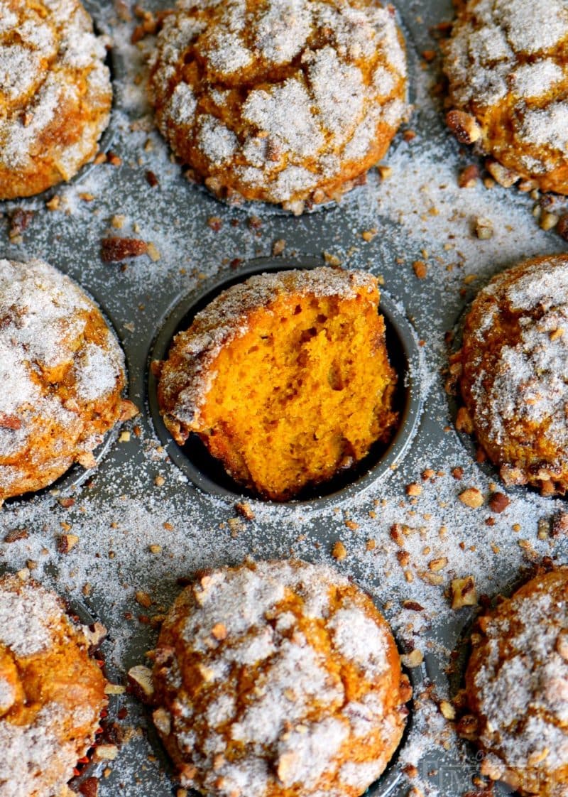 pumpkin muffins in muffin tin with sugar sprinkled around