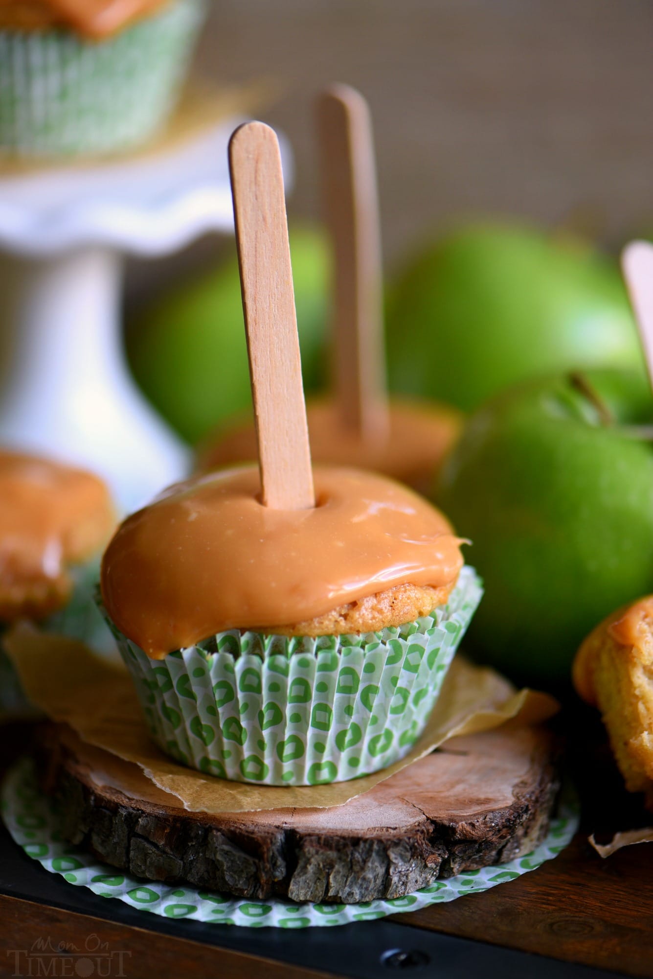 There is no better way to usher in fall than with these delicious Caramel Apple Cupcakes. Moist cupcakes loaded with apples and applesauce for double the apple flavor. A decadent caramel frosting tops them off beautifully. The perfect fall treat! Popsicle sticks not optional. // Mom On Timeout