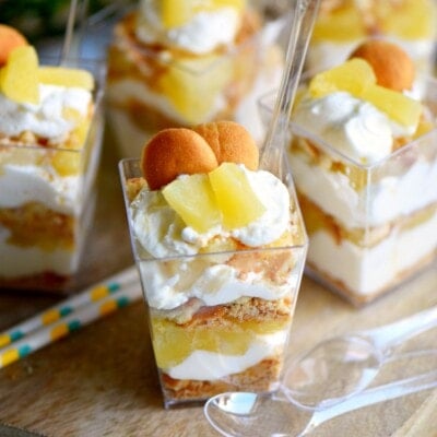 mini pineapple cheesecake trifle in small single serving containers topped with mini nilla wafers.