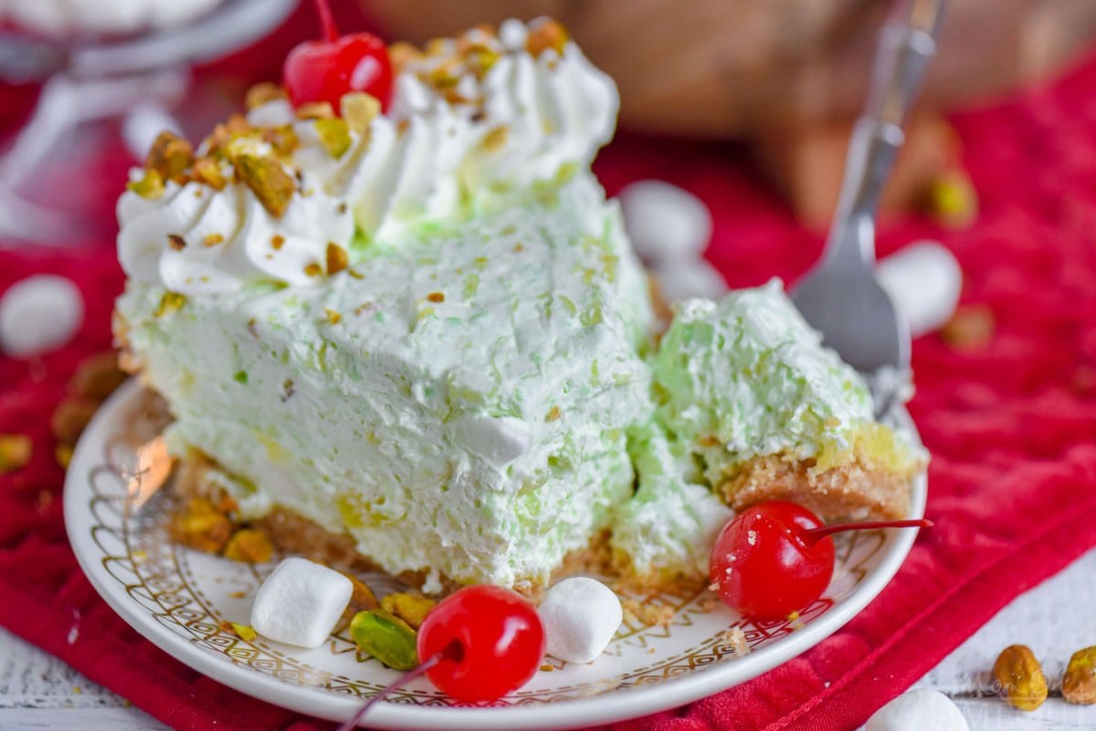 single piece of pie on small dessert plate with a forkful of the pie resting on the edge of the plate.