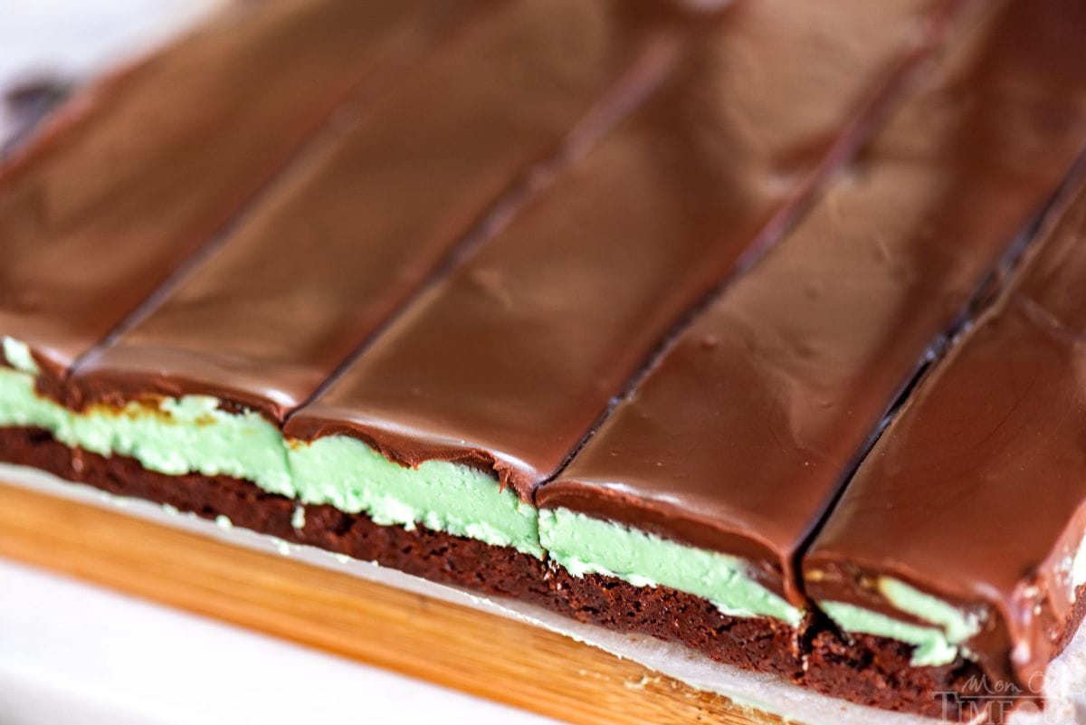 wide shot of mint brownies on cutting board showing cross section so all three layers can be seen clearly.