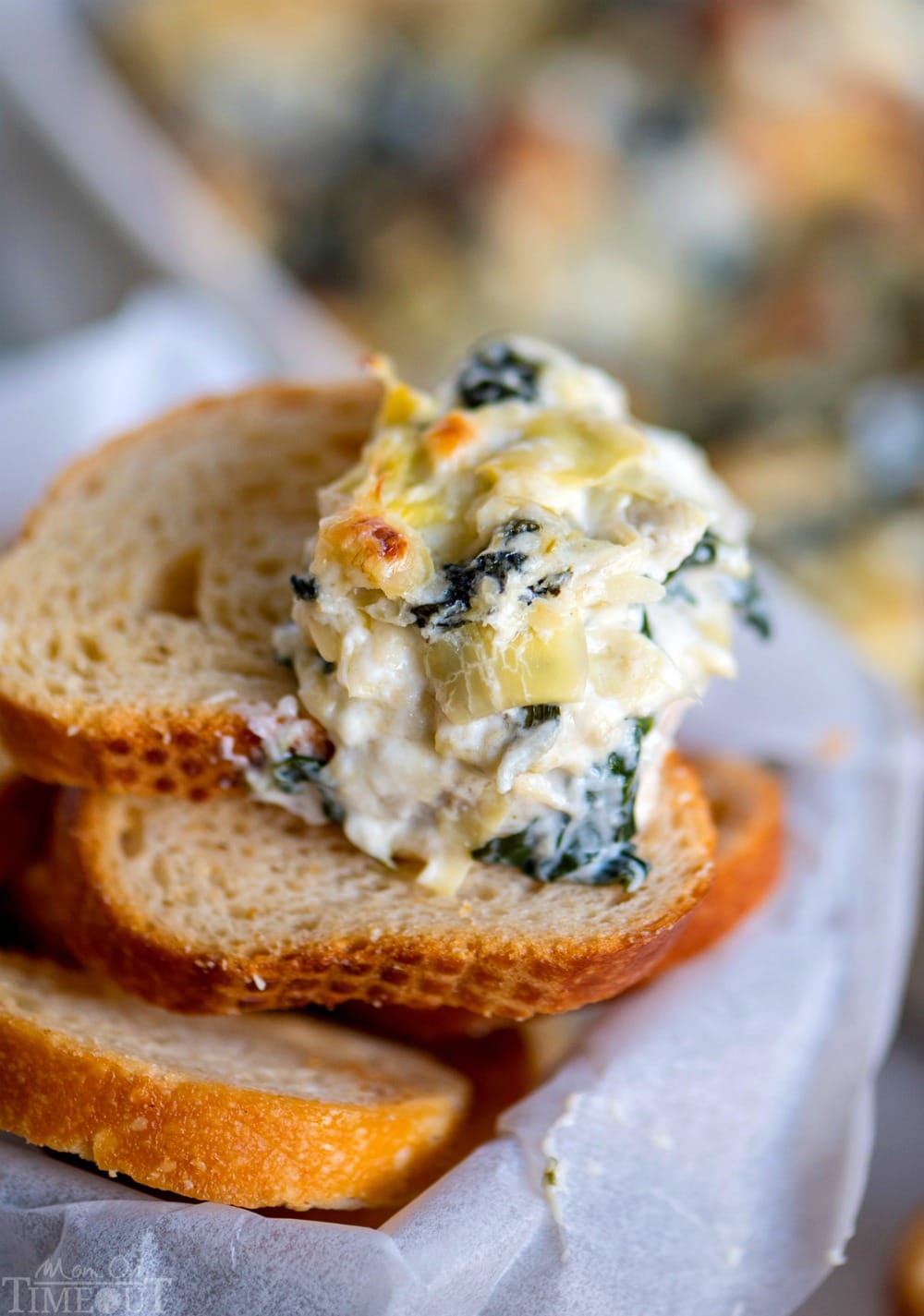 spinach and artichoke dip on baguette slices