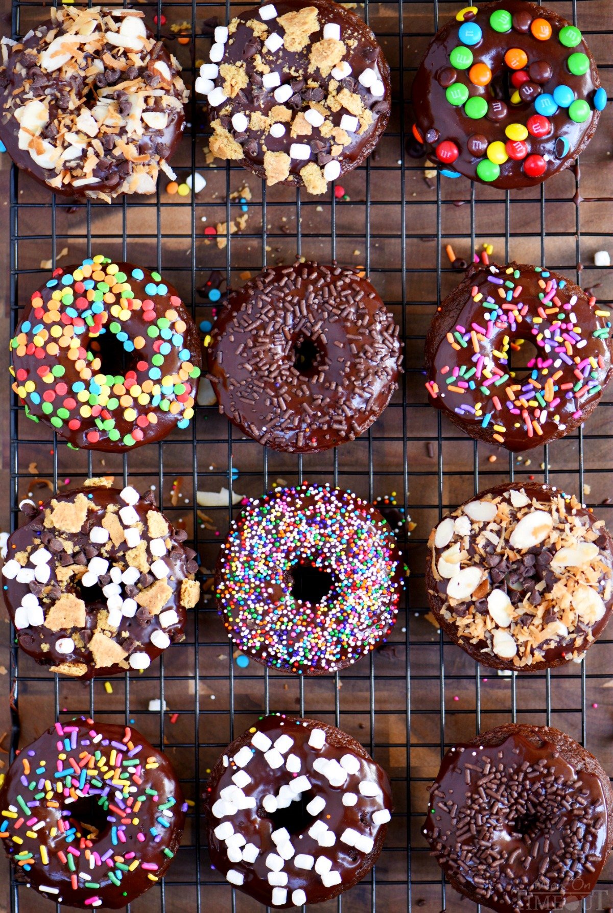 Start your mornings off right with CHOCOLATE! These Chocolate Cake Mix Donuts are topped with a silky chocolate glaze and an assortment of fun toppings. S'mores, Almond Joy, sprinkles - which will be your new favorite? // Mom On Timeout 