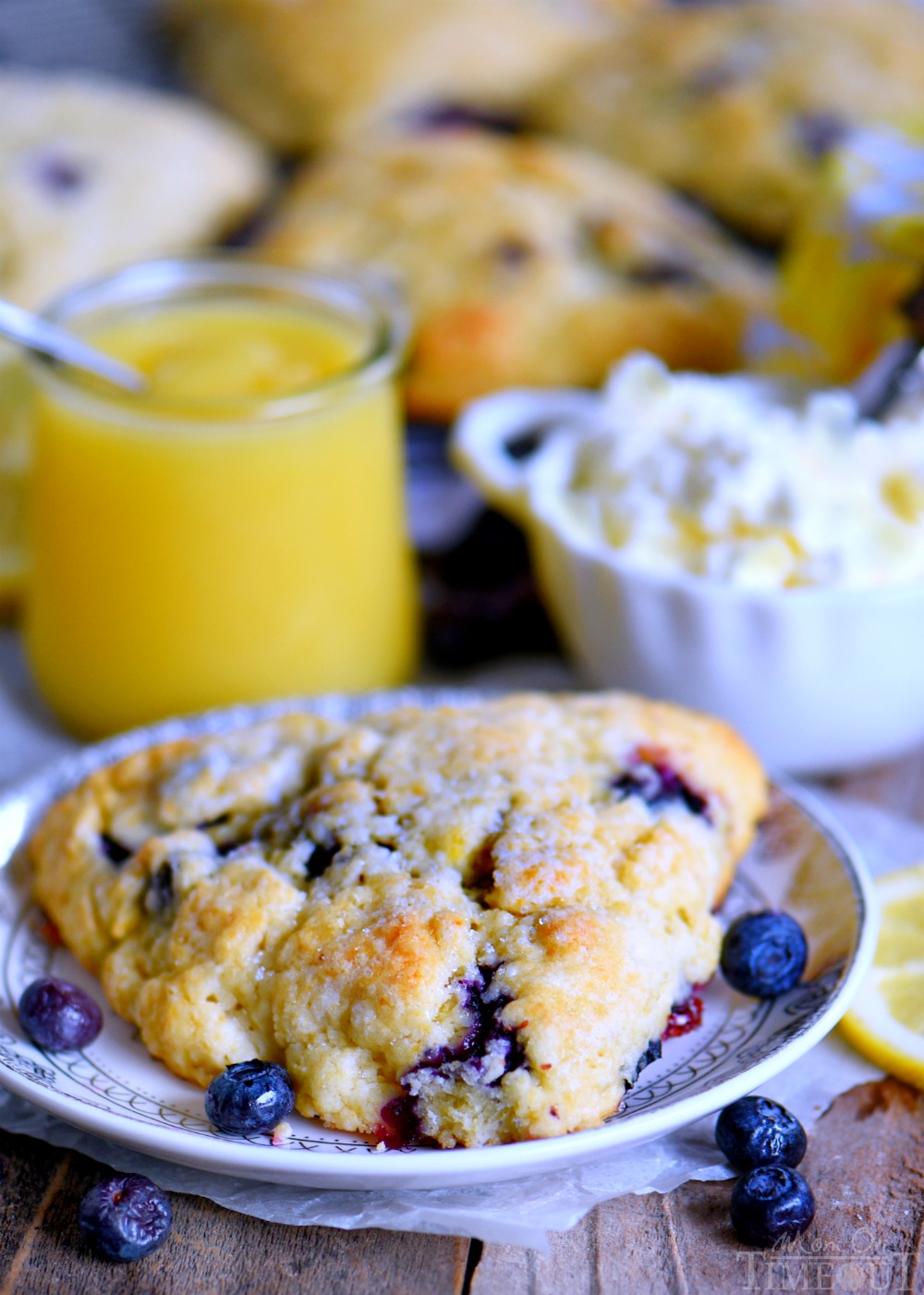 This easy Lemon Blueberry Scones recipe is a delightful addition to any breakfast or brunch! Fresh blueberries and loads of lemon zest add an irresistible freshness to these easy to make scones. Serve with lemon curd and cream for an afternoon tea experience everyone will love! // Mom On Timeout lemon-blueberry-scones-easy-recipe-plate