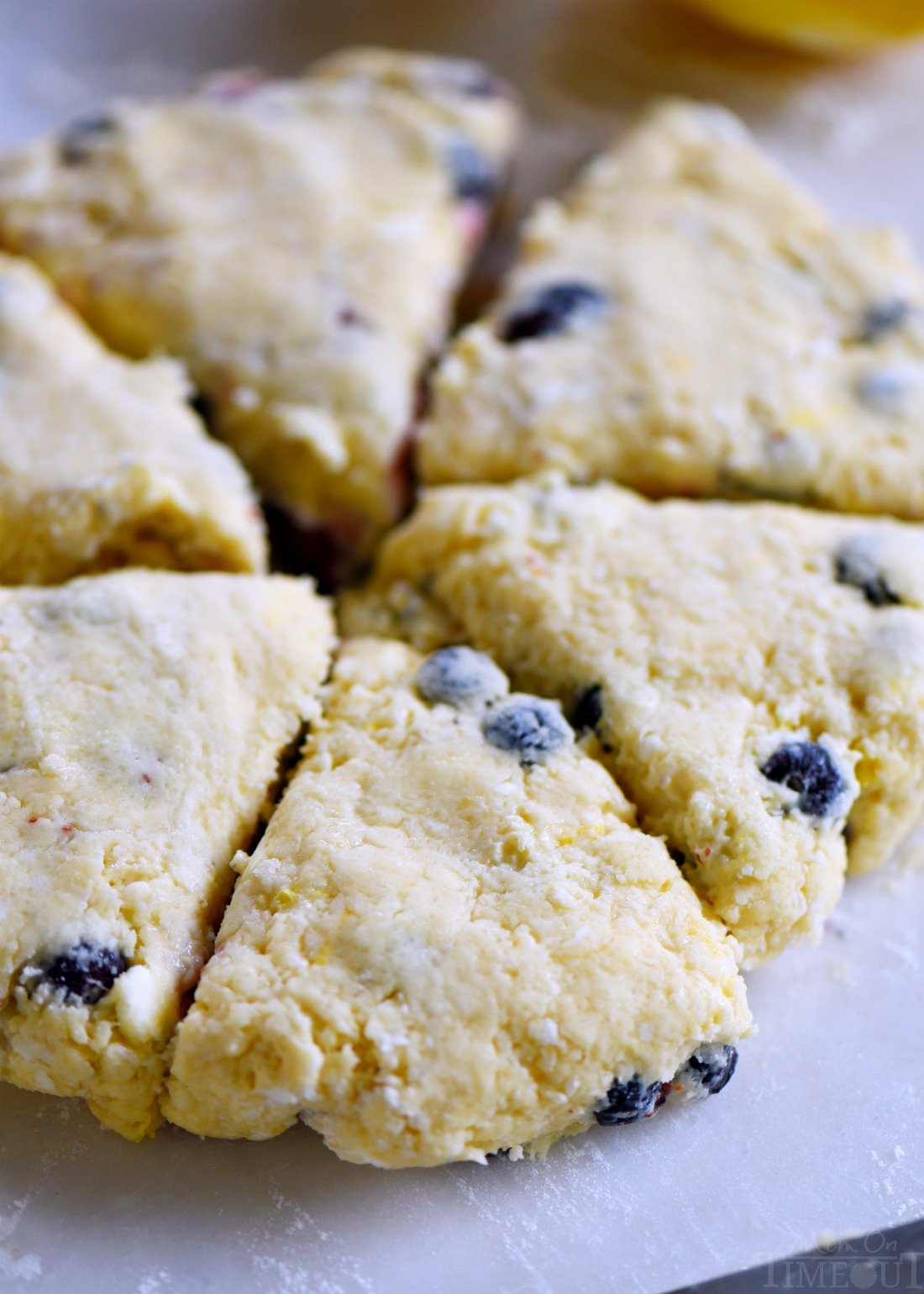 Easy Lemon Blueberry Scones are a delightful addition to any breakfast or brunch! Fresh blueberries and loads of lemon zest add an irresistible freshness to these easy to make scones. Serve with lemon curd and cream for an afternoon tea experience everyone will love! // Mom On Timeout #brunch #breakfast #tea #blueberries #blueberry #lemon #scones #scone #recipe #recipes emon-blueberry-scones-fresh-blueberries-disc