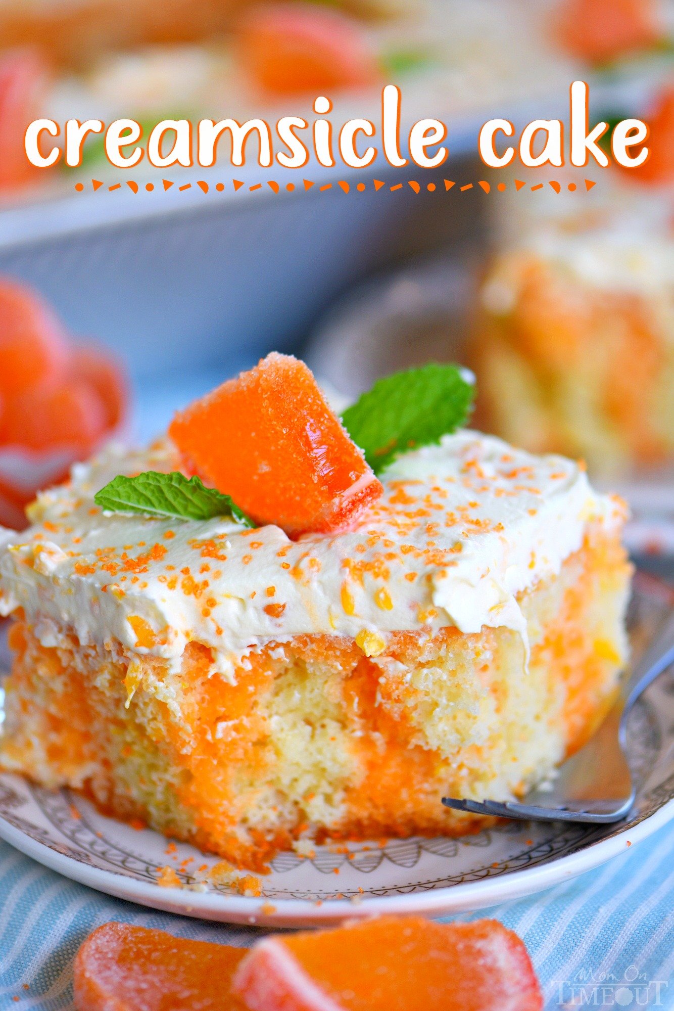 piece of orange creamsicle cake with mint leaves on small plate with fork