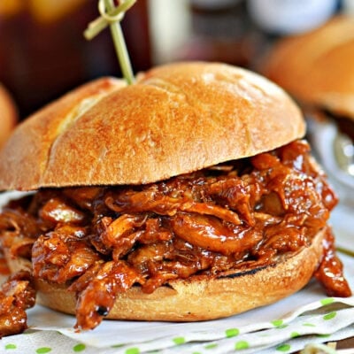 bbq chicken sandwich made with pulled chicken. Sitting on a green and white napkin.
