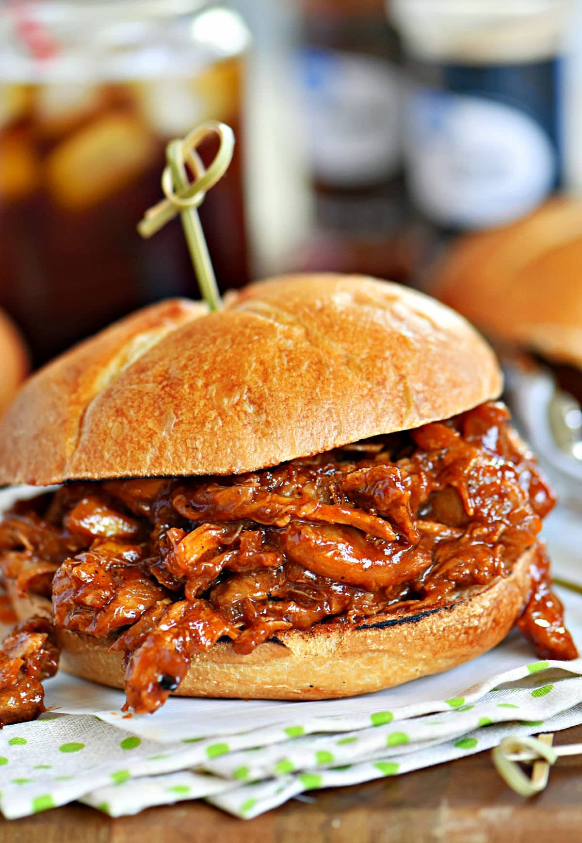 bbq chicken sandwich made with pulled chicken. Sitting on a green and white napkin.