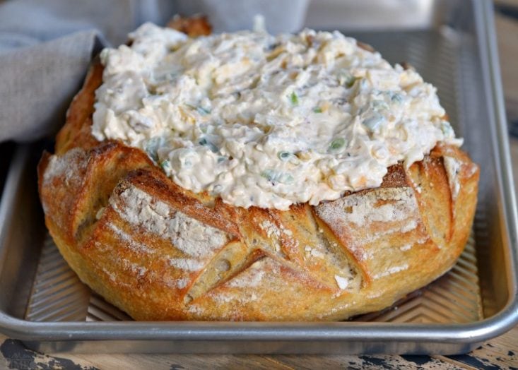 This Baked Bacon Cheese Dip is the ULTIMATE party food. This creamy cheese dip is made with five different types of cheese, is loaded with bacon and baked up in a bread bowl that makes serving a breeze. Use your choice of dippers including fresh veggies, chips, pretzels, crostini, or fresh bread. You simply can't go wrong. // Mom On Timeout #bacon #cheese #appetizer #bread #dip #recipe #recipes #appetizers #ad baked-bacon-cheese-dip-in-bread-bowl