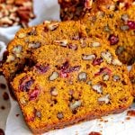 two slices of pumpkin bread made with cranberries and pecans.