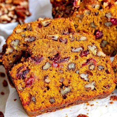 two slices of pumpkin bread made with cranberries and pecans.