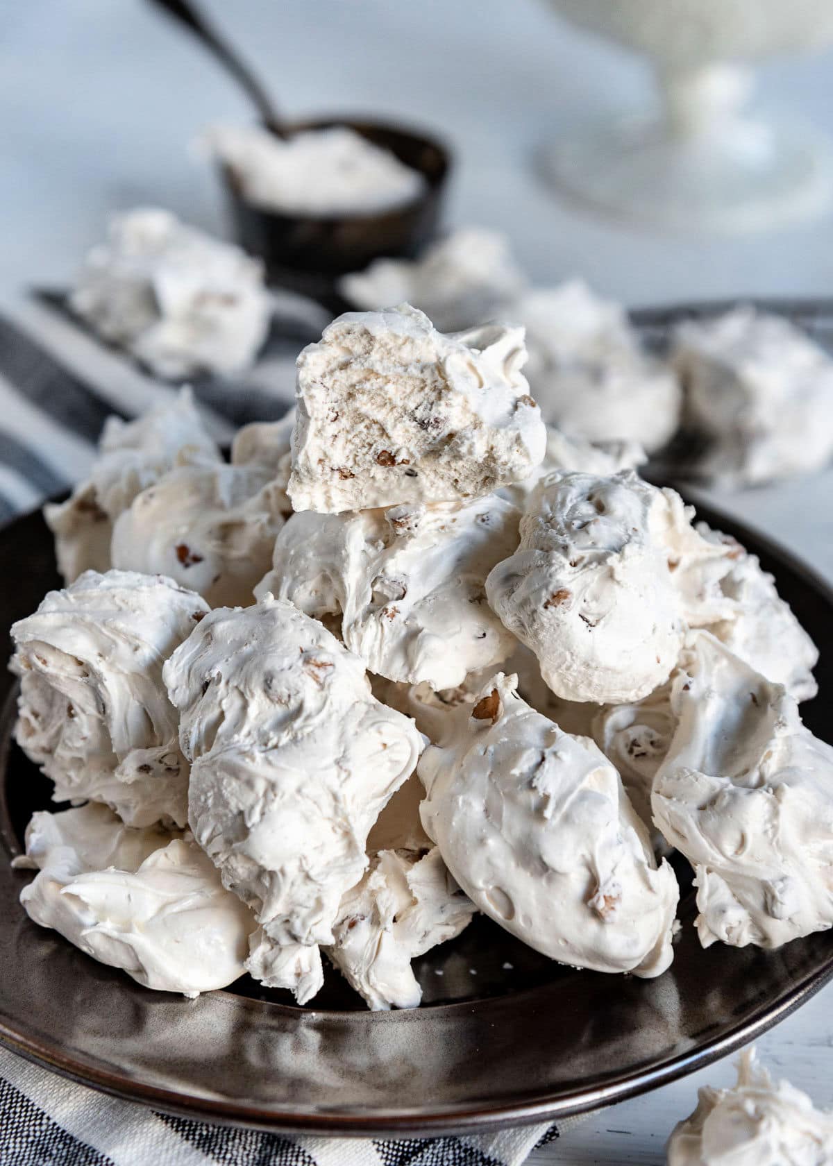 silver plate topped with lots of divinity candy piled high. top piece of divinity is broken in half.