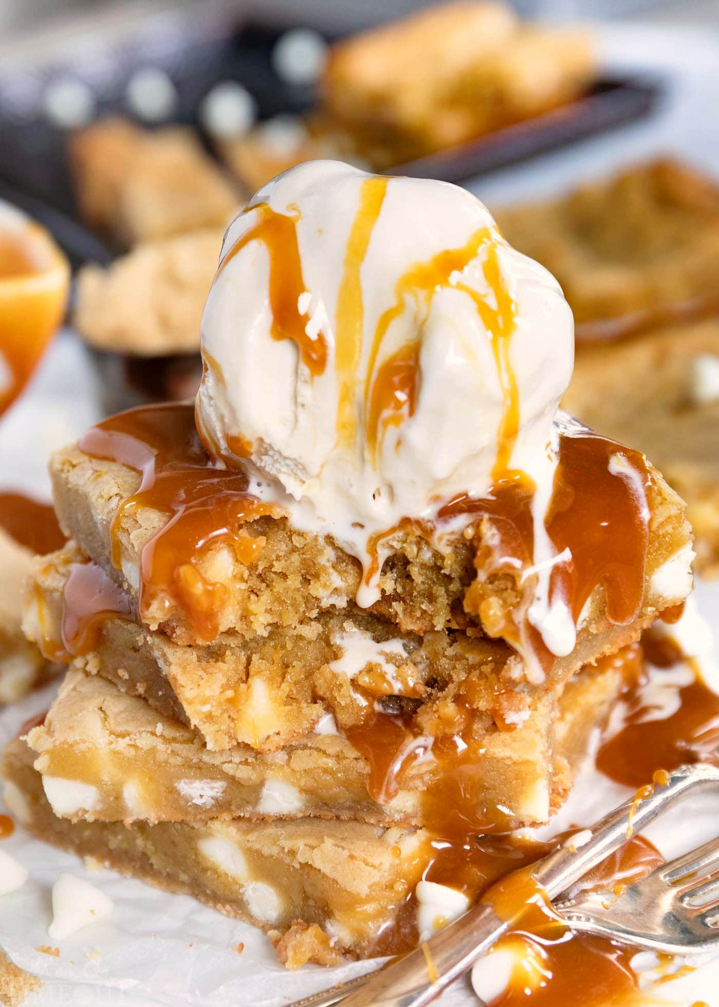 stack of 4 blondies topped with vanilla ice cream and caramel sauce.