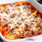 what baking dish with baked stuffed shells topped with fresh basil and melted cheese ready to be served.