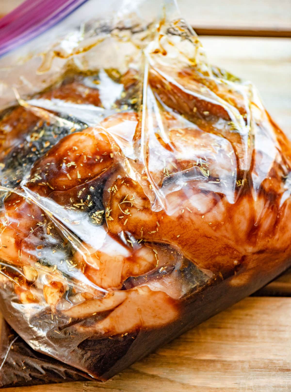 chicken breasts marinating in plastic bag.