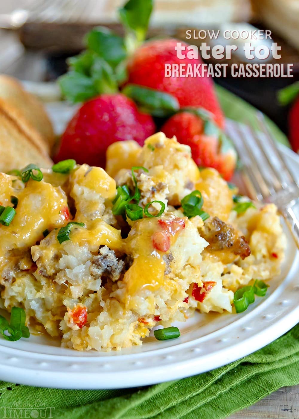 This delicious Slow Cooker Tater Tot Breakfast Casserole is an easy, comfort food dish that is perfect any day of the week. Loaded with eggs, sausage, cheese and tater tots, this simple breakfast casserole is served up straight from your slow cooker! // Mom On Timeout #slowcooker #tatertotcasserole #breakfastcasserole #breakfast #slowcooker #crockpot #tatertots #sausage #cheese #brunch breakfast-tater-tot-casserole-on-plate with strawberries and toast