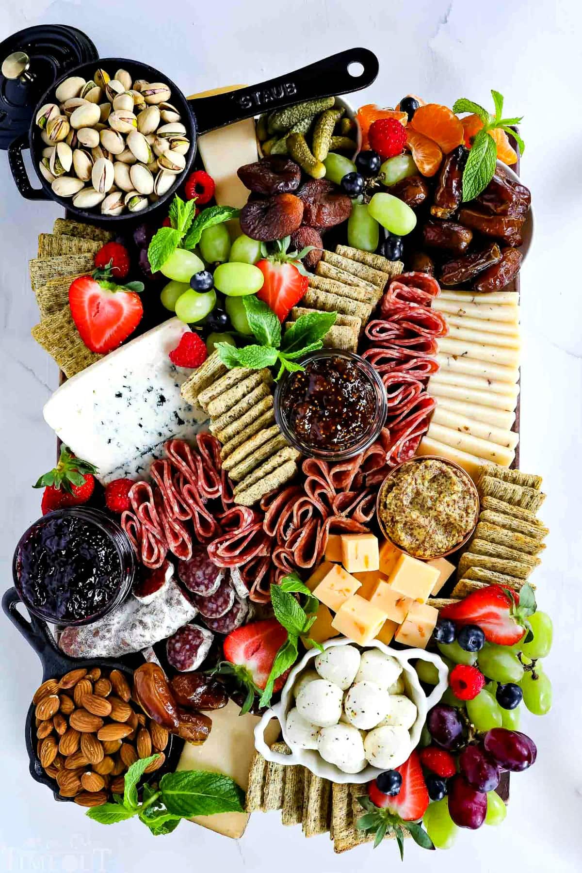 charcuterie-board-bowls-fruit-cheese-salami-nuts-crackers