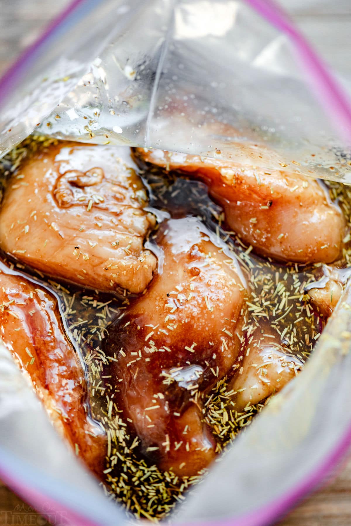 top down view of chicken marinating in large resealable bag.