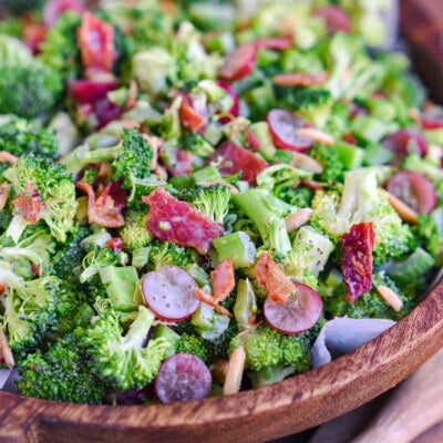 dark brown wood bowl filled with freshly prepare broccoli salad recipe made with grapes and bacon.