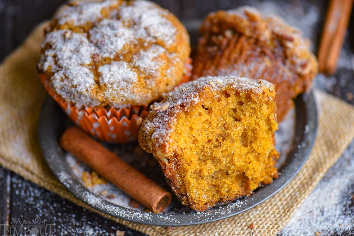 Wide shot of pumpkin muffins recipe on metal round plate with cinnamon stick to the side.
