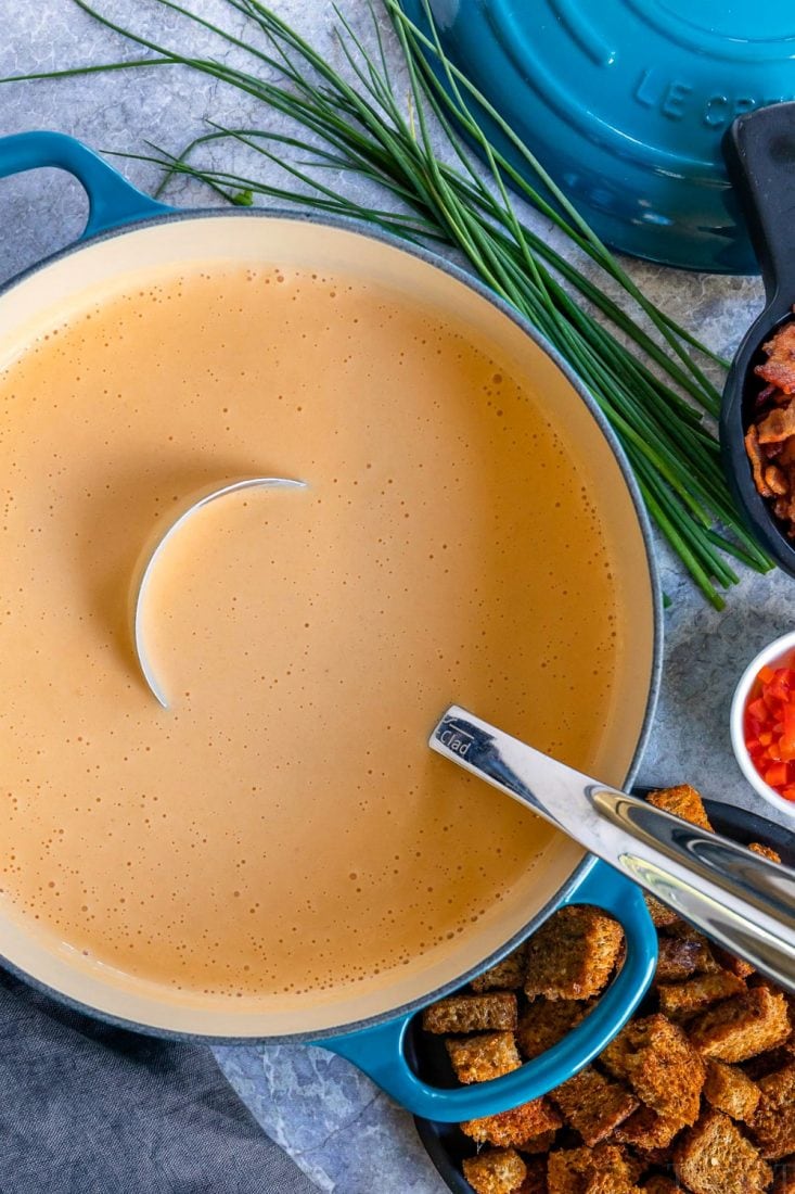 This easy Beer Cheese Soup is the perfect way to warm up on a chilly, fall day. Loaded with bacon, beer and cheese, this comforting soup is perfect for game day! // Mom On Timeout #beercheesesoup #souprecipes #soup #dinner #beer #bacon #cheese beer cheese soup in pot with ladle