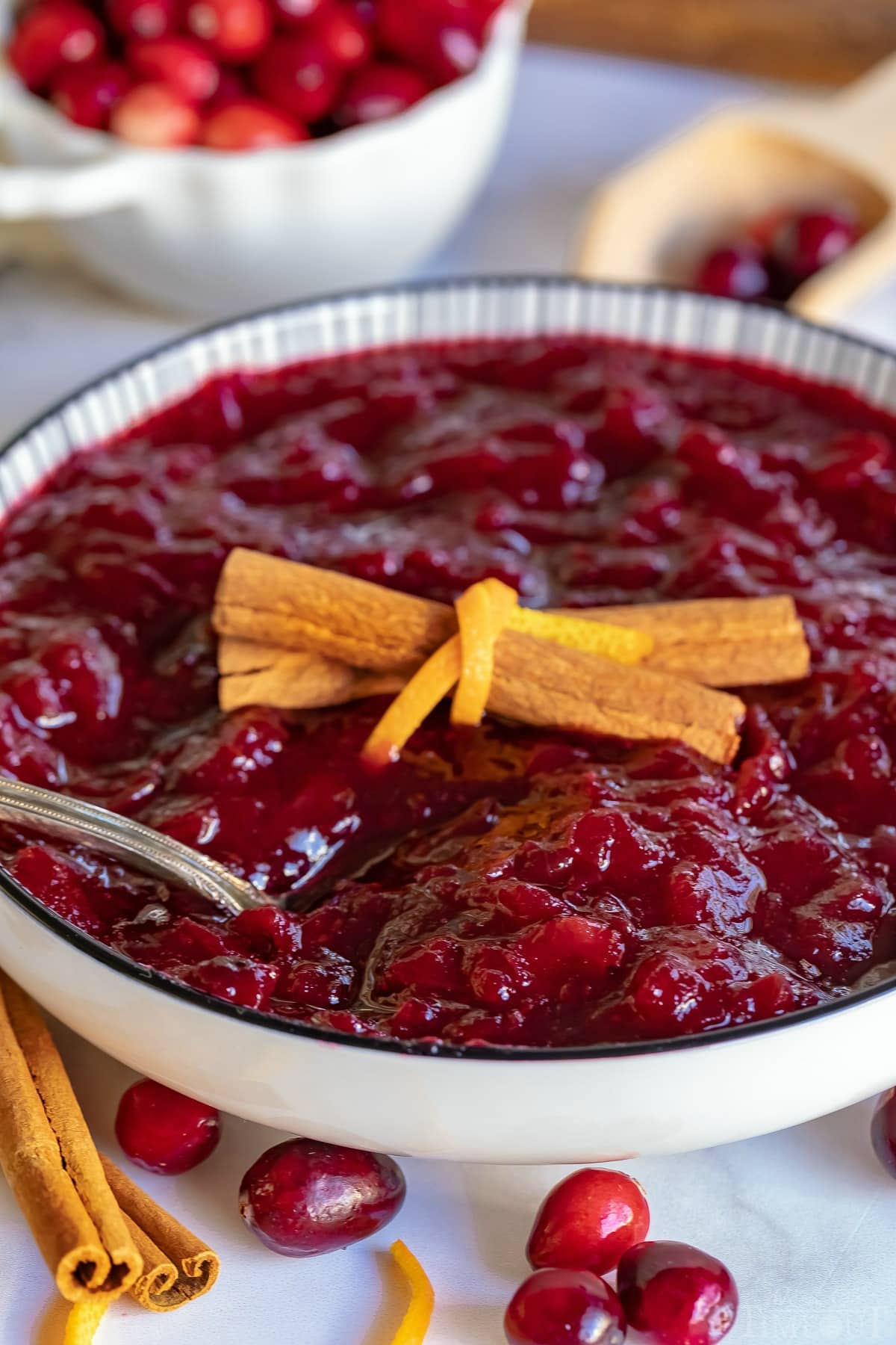 cranberry sauce recipe in bowl garnished with cinnamon and orange peel