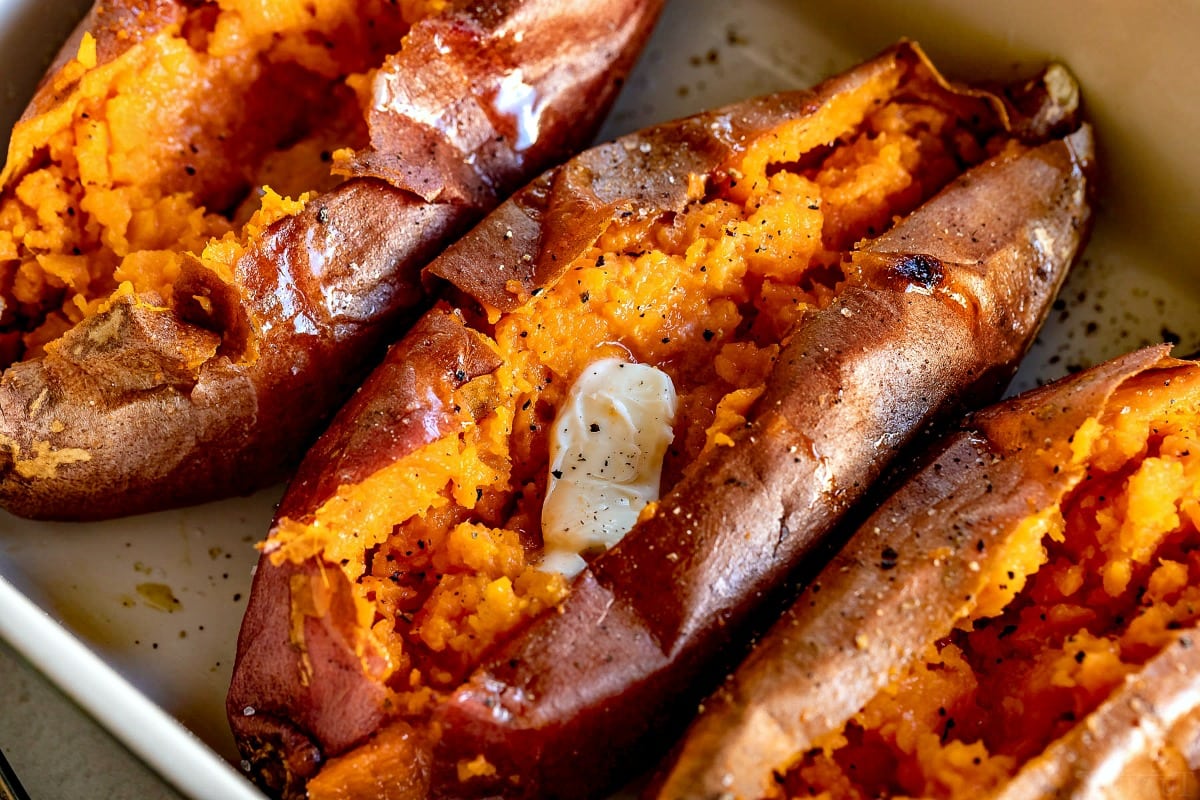 Oven baked sweet potatoes in baking dish with butter salt and pepper.