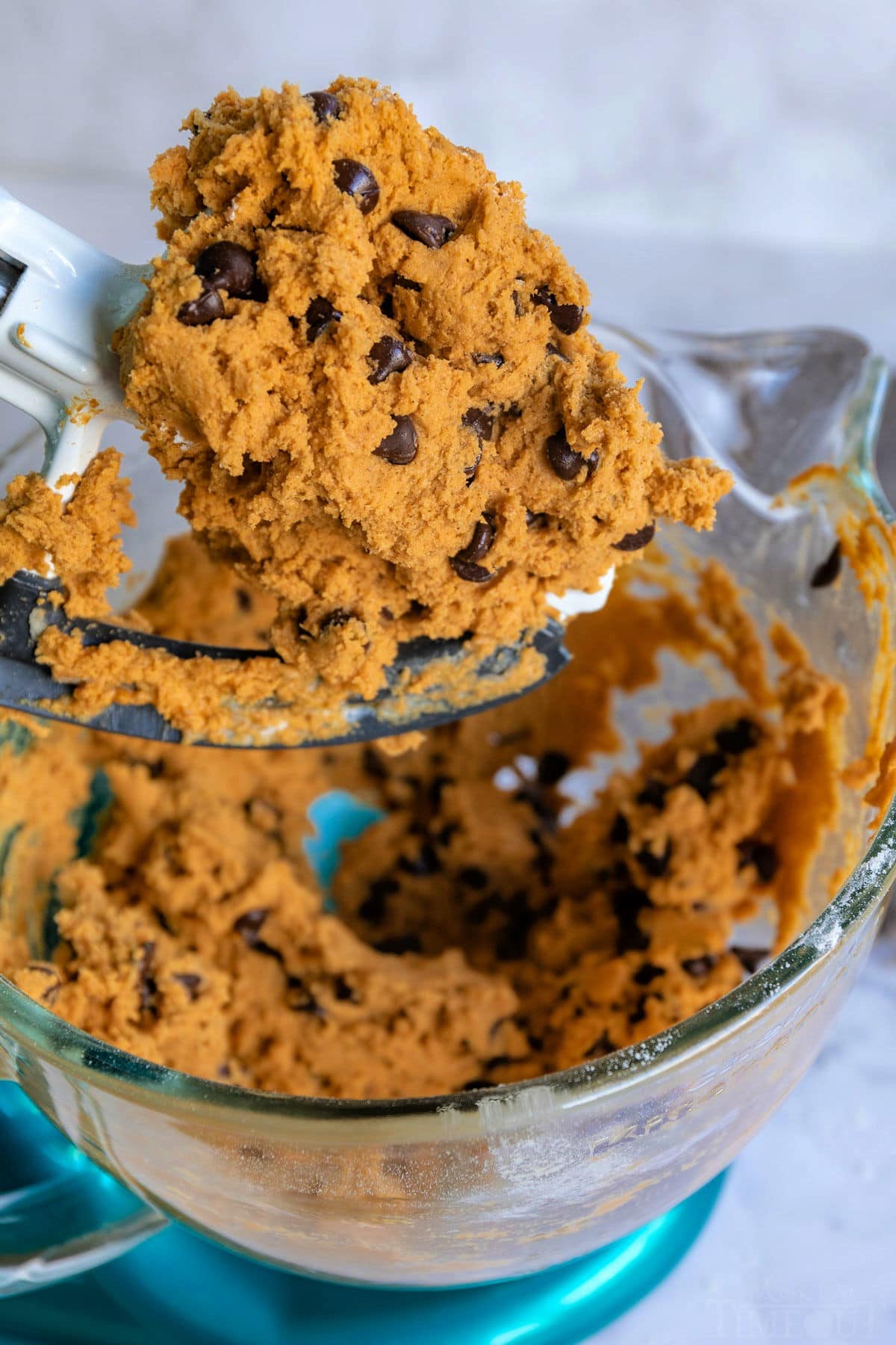 These Pumpkin Chocolate Chip Cookies are soft and chewy with loads of pumpkin flavor! Pumpkin pie spice and pumpkin puree work together to create an amazing pumpkin chocolate chip cookie recipe that's just perfect for the holidays! // Mom On Timeout #pumpkinchocolatechipcookies #pumpkin #chocolatechipcookies #cookies #baking #fall #holidays #thanksgiving #christmas pumpkin chocolate chip cookie recipe dough in mixing bowl still on beater and in bowl.