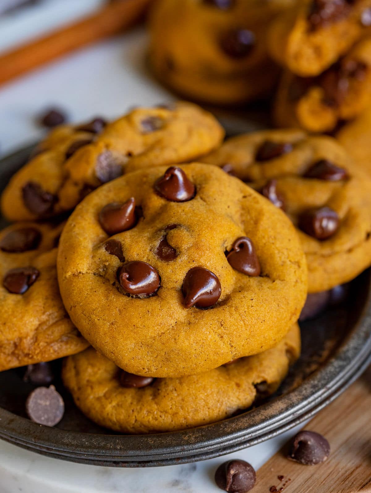 whole pumpkin cookies sitting on metal tray made with chocolate chips.