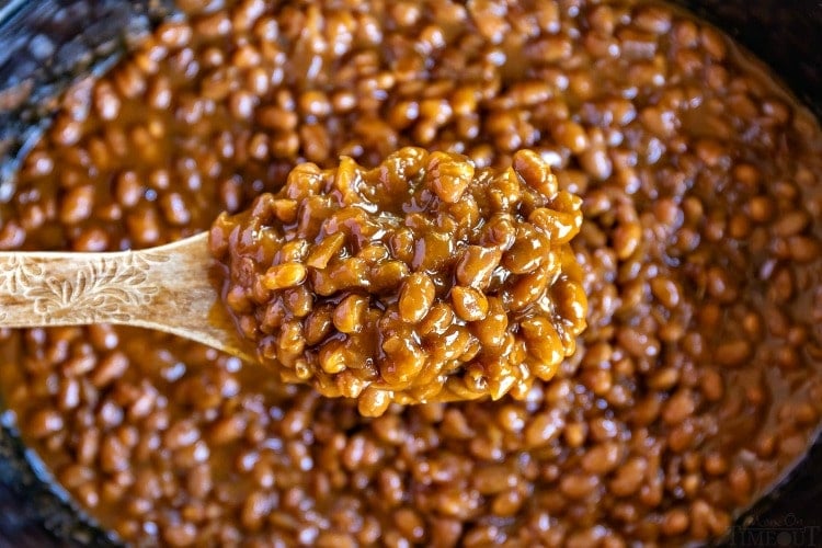 baked beans in slow cooker on wooden spoon wide