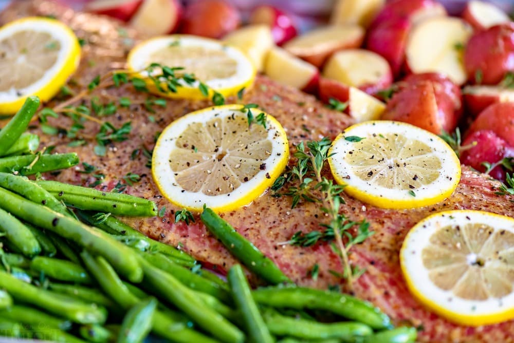 Easy Baked Salmon is healthy, delicious, and FAST! Fresh salmon is topped with a simple honey dijon glaze and baked to perfection. Prepped and cooked in under 30 minutes! // Mom On Timeout #bakedsalmon #salmon #salmonrecipe #easysalmonrecipe #easy #sheetpan #dinner #dinners #30minutemeals #veggies baked salmon honey dijon glaze with green beans and red potatoes on sheet pan