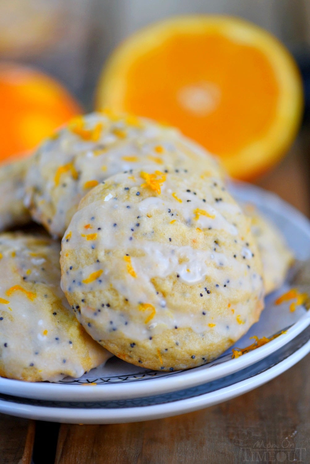 orange poppy seed cookies with orange glaze stacked on plate