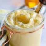 honey butter in jar with knife and extra honey