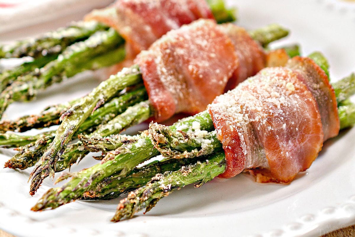 bacon wrapped asparagus plated on white plate