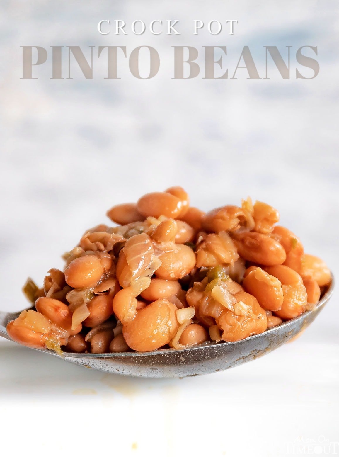 pinto beans recipe in a serving spoon with white crockpot with text overlay