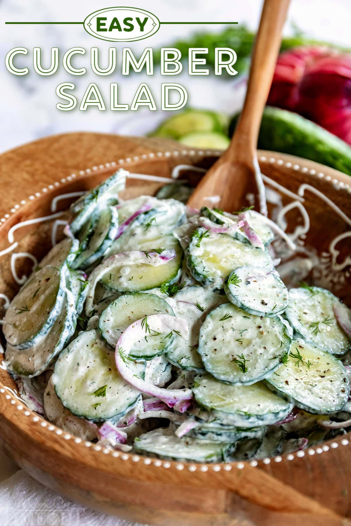 cucumber salad in wood bowl with wooden spoon